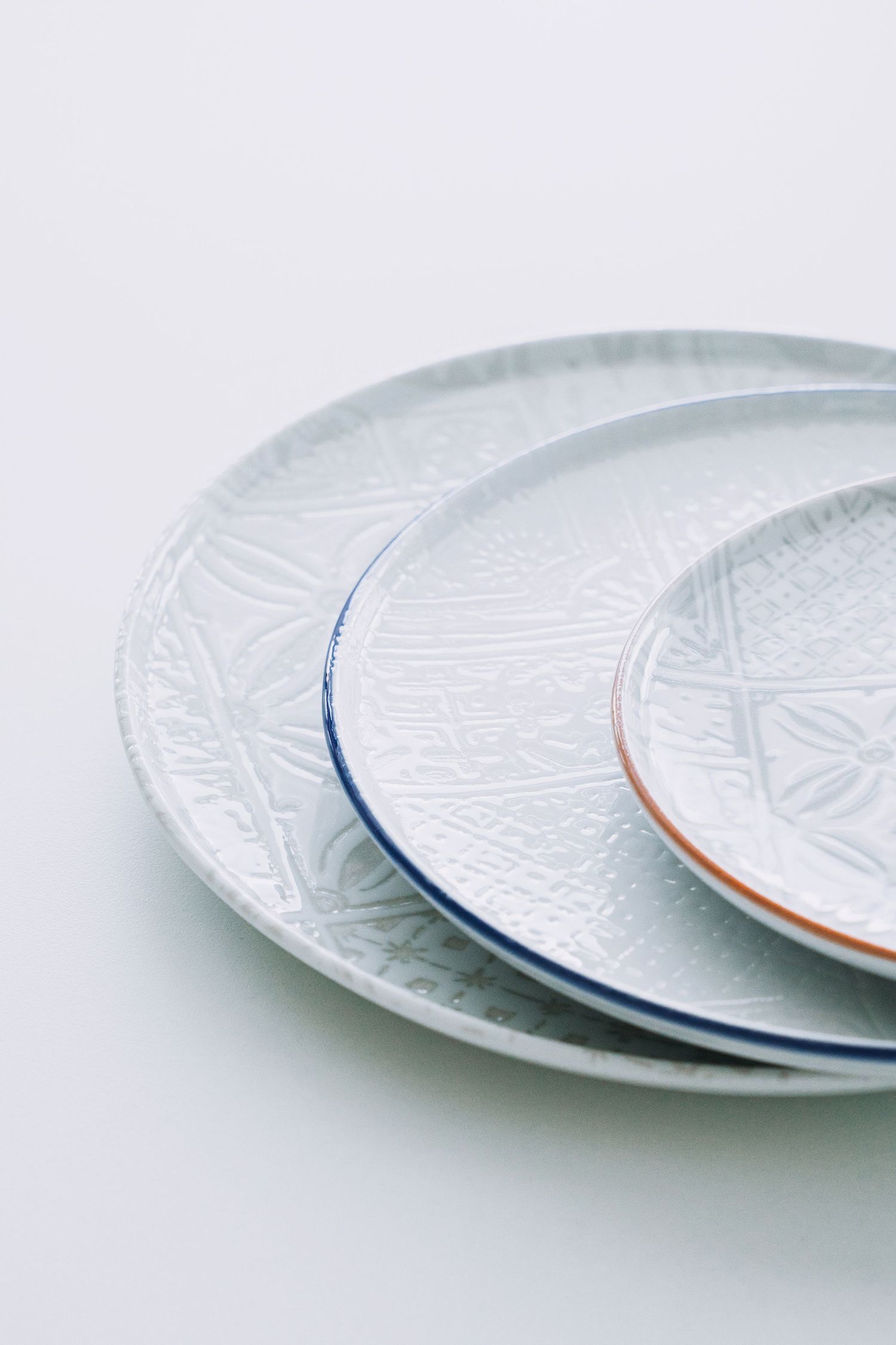 Digitally printed porcelain plates and bowls with mosaic patterns, arranged on a hard porcelain.