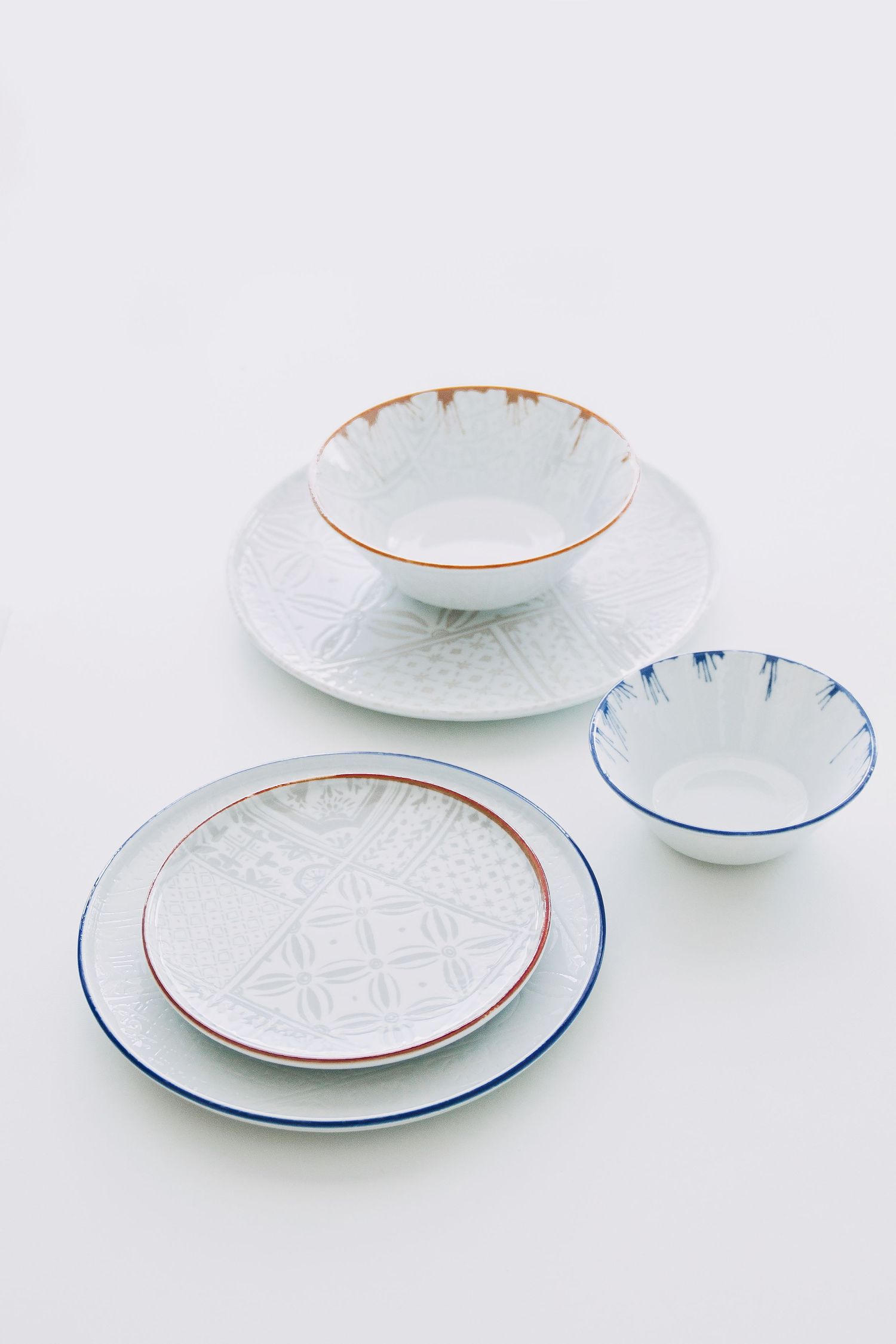 Digitally printed porcelain plates and bowls with mosaic patterns, arranged on a hard porcelain.