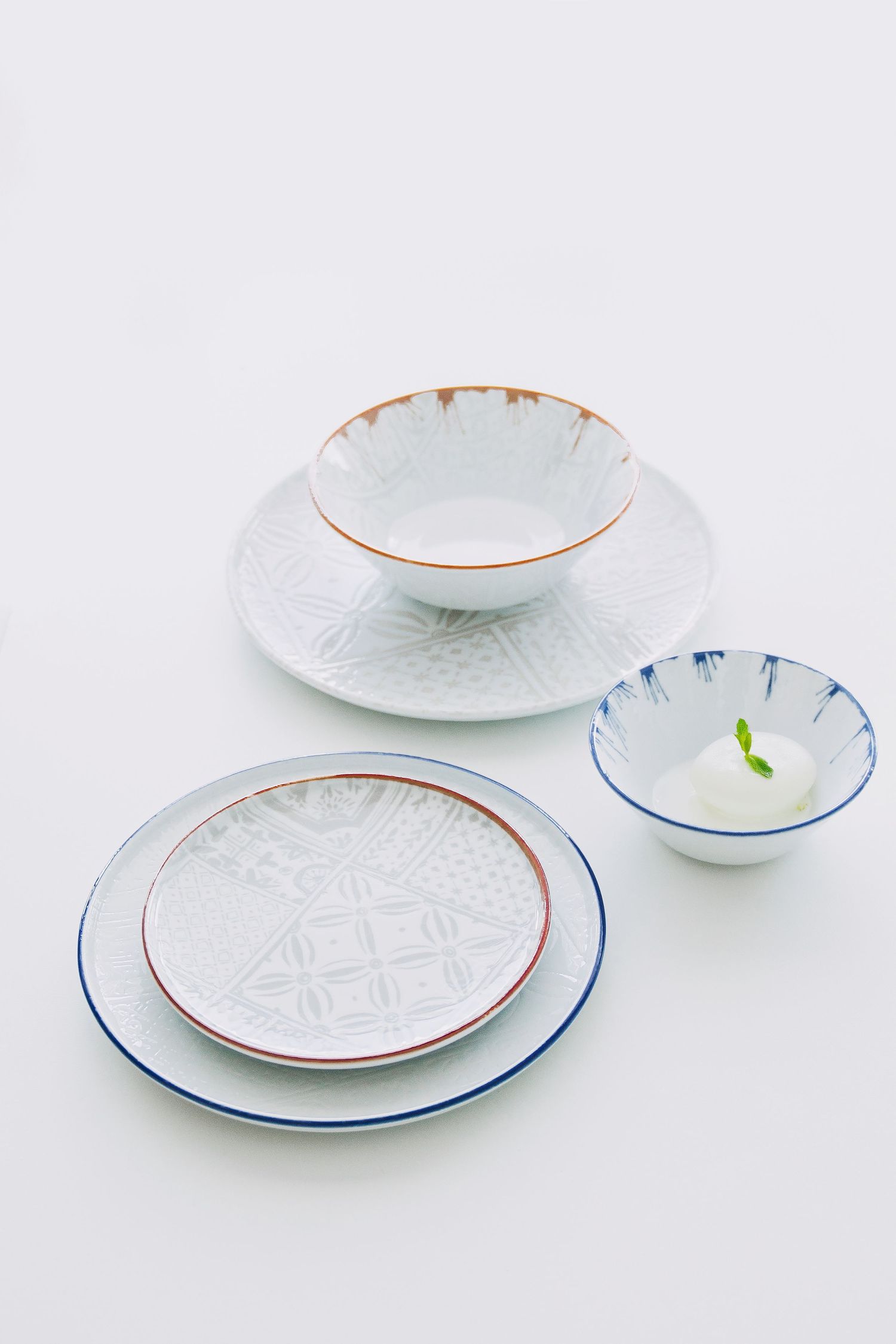 Digitally printed porcelain plates and bowls with mosaic patterns, arranged on a hard porcelain.