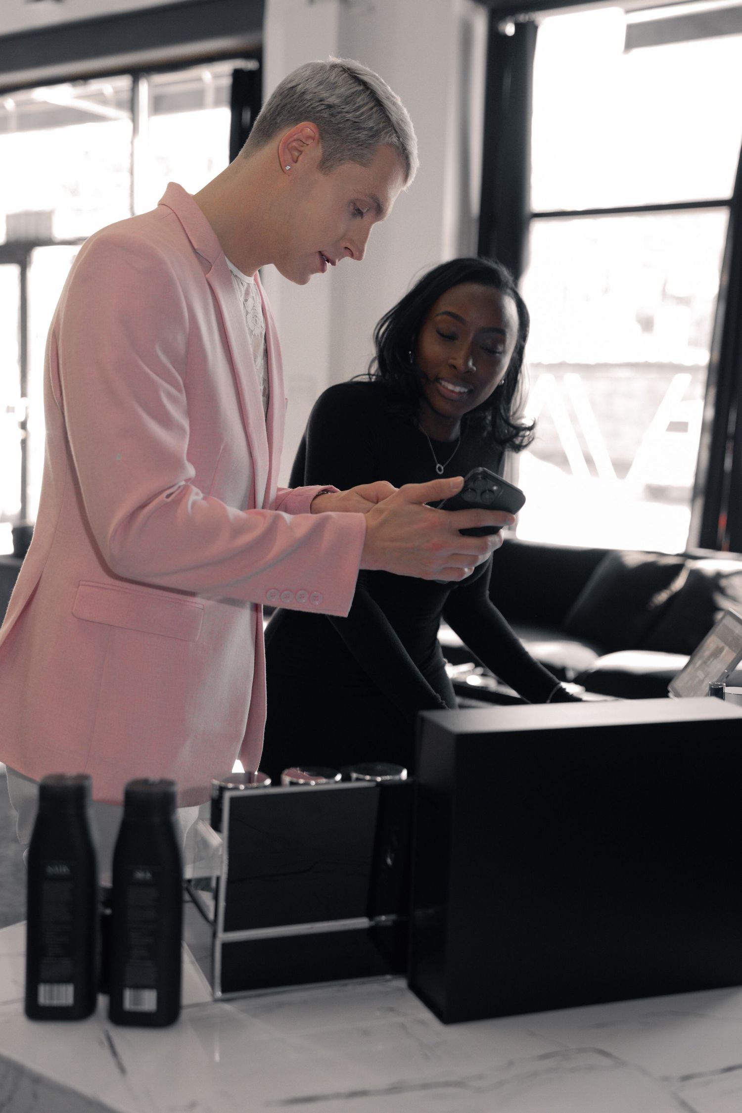 Two professionals looking at mobile device in modern office setting.
