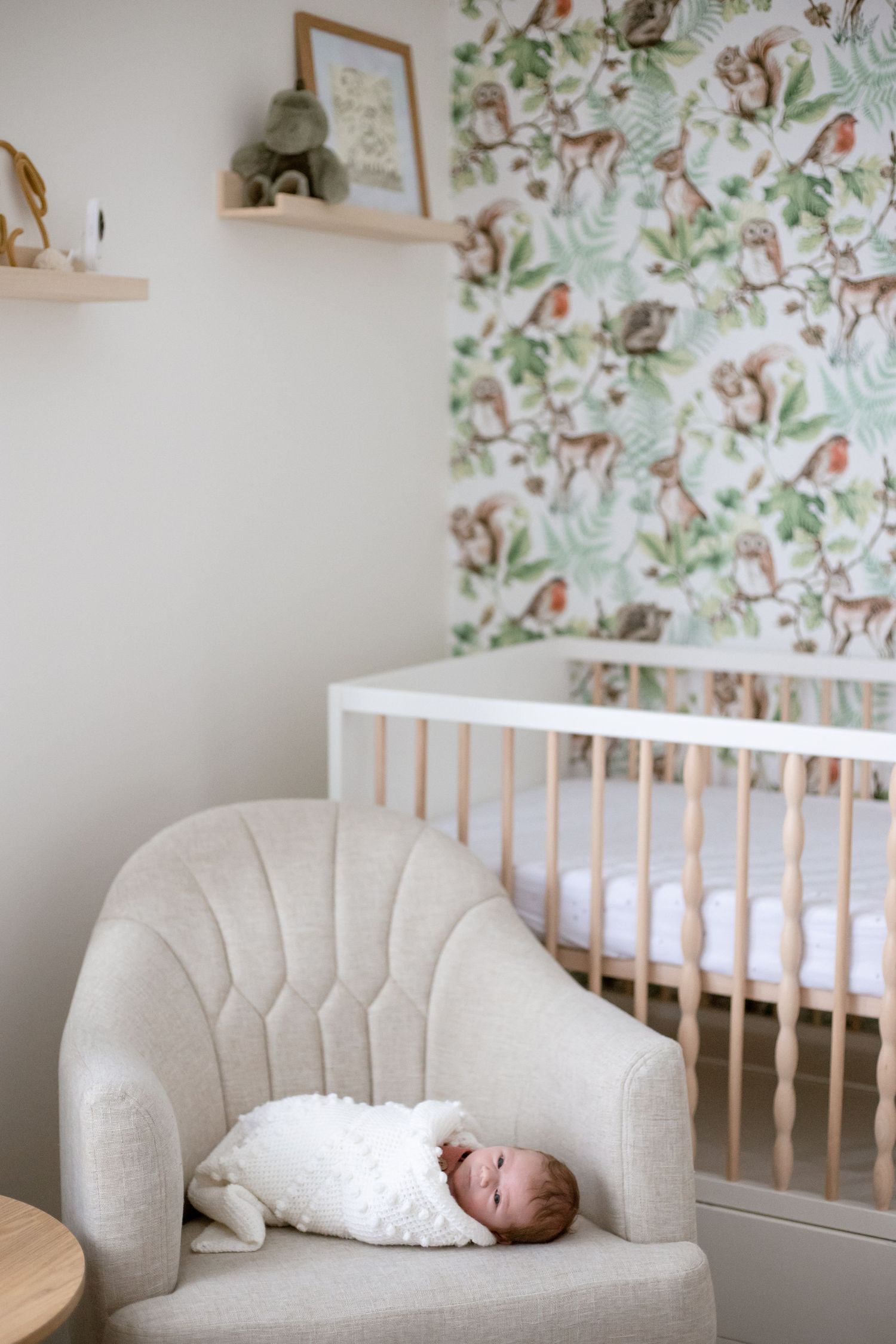 photo of newborn baby wrapped up on a chair in the home nursery