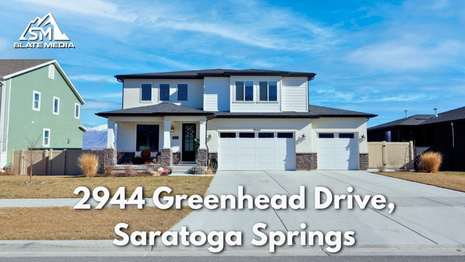 Modern two-story home at 2944 Greenhead Drive Saratoga Springs with a three-car garage and blue sky. Captured by Slate Media (best in UT)