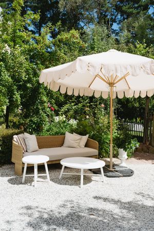 Elegant outdoor lounge area with white umbrella and wicker furniture on gravel patio.Best wedding photographer in Adelaide SA