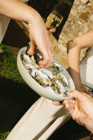 Hands arranging flowers in a stone garden urn outdoors. Best wedding photographer in Adelaide SA