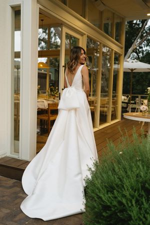 Long white wedding dress train flowing behind bride on covered porch.Best wedding photographer in Adelaide SA