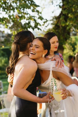 Wedding guests sharing joyful embraces and drinks during outdoor reception celebration. Best wedding photographer in Adelaide SA