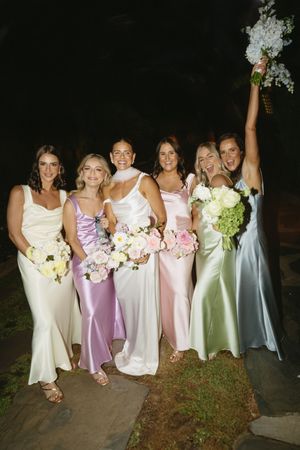 Wedding party in pastel silk dresses pose with bouquets during evening celebration. Best wedding photographer in Adelaide SA
