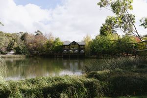 Serene lakeside view of a charming boathouse surrounded by lush greenery. Best wedding photographer in Adelaide SA