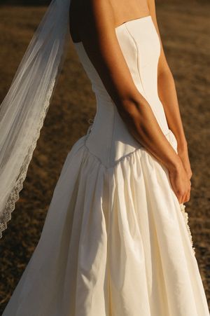 Close-up detail of a white wedding dress with delicate lace trim in golden sunlight. Best wedding photographer in Adelaide SA