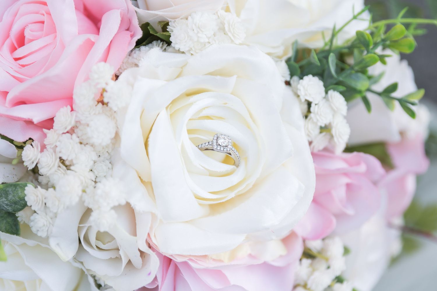 An up close picture of the bride's ring within a floral arrangement.