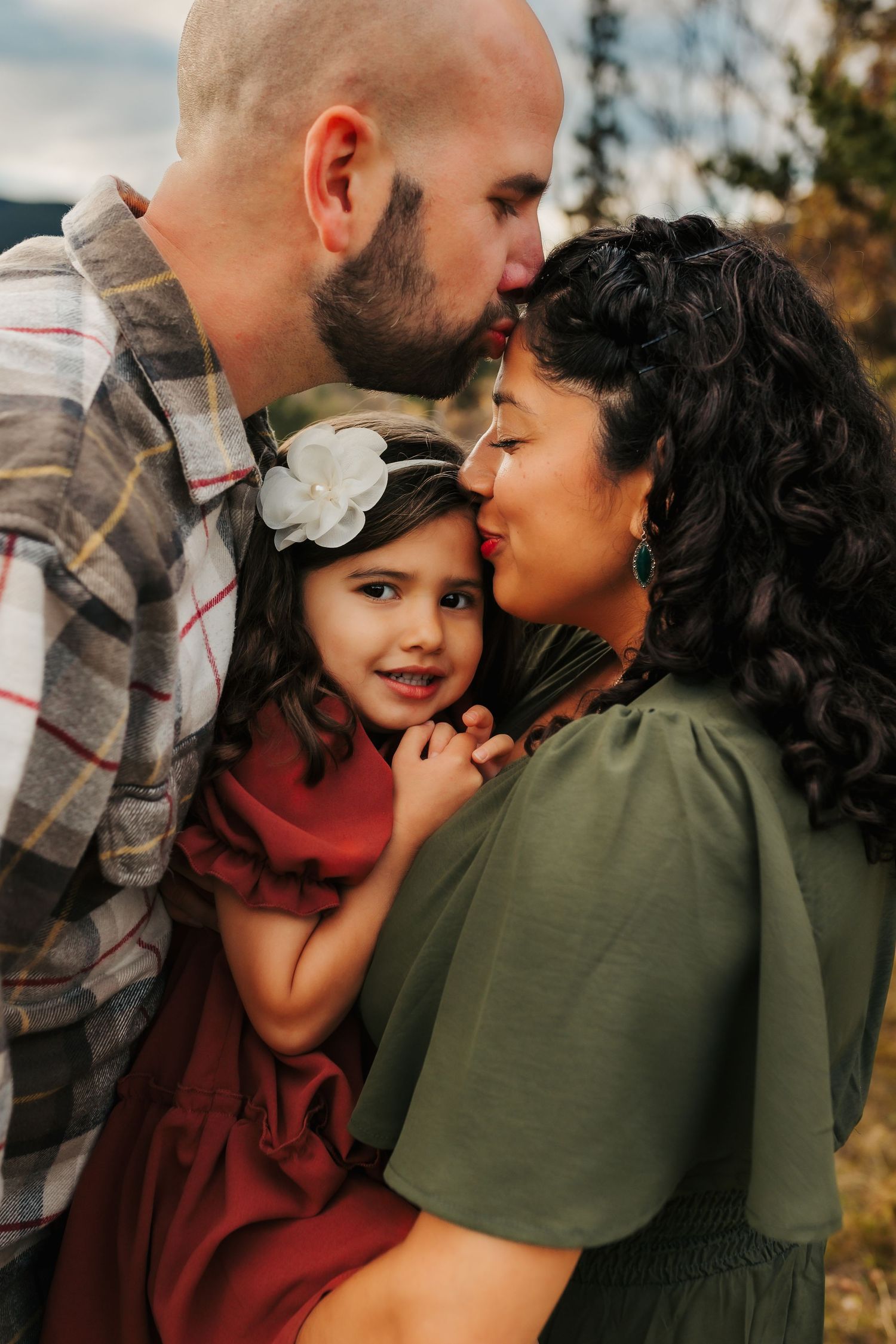 Tender family moment outdoors with warm embraces and genuine smiles.