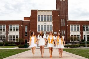 four grads walking hand in hand