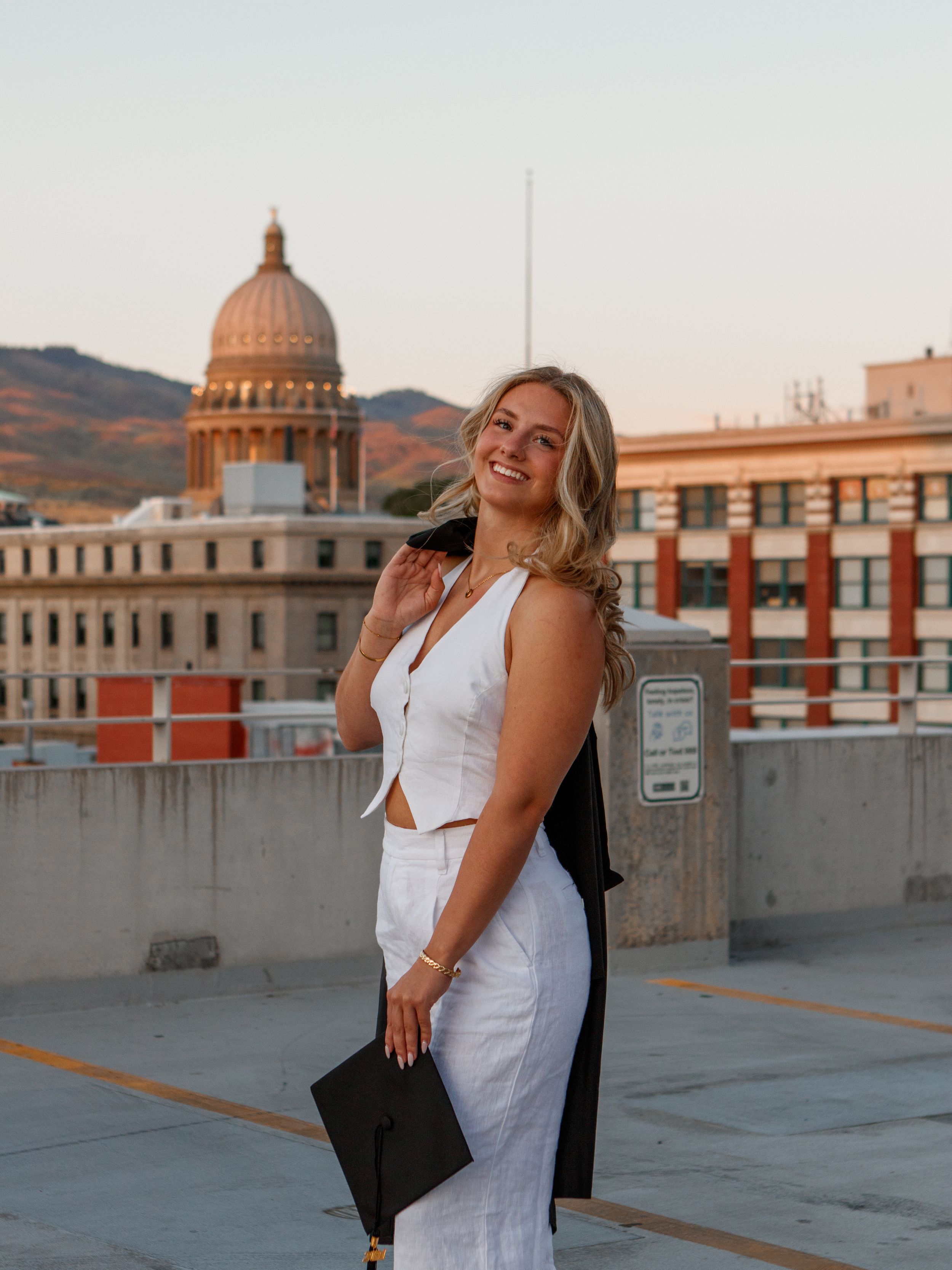 a grad posing with her cap and gown in downtown Boise