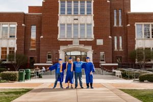 four grads posing together, smiling