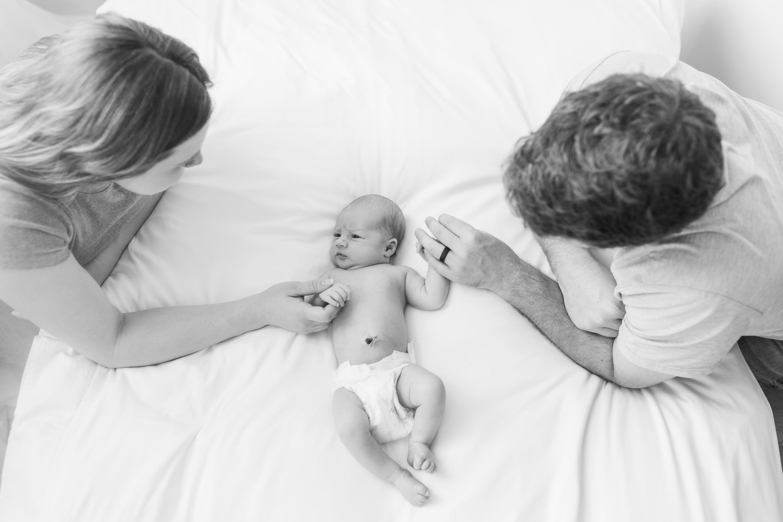 Intimate black and white newborn photography session with gentle poses.