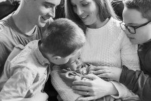 Intimate lifestyle newborn photography session with family on a couch.