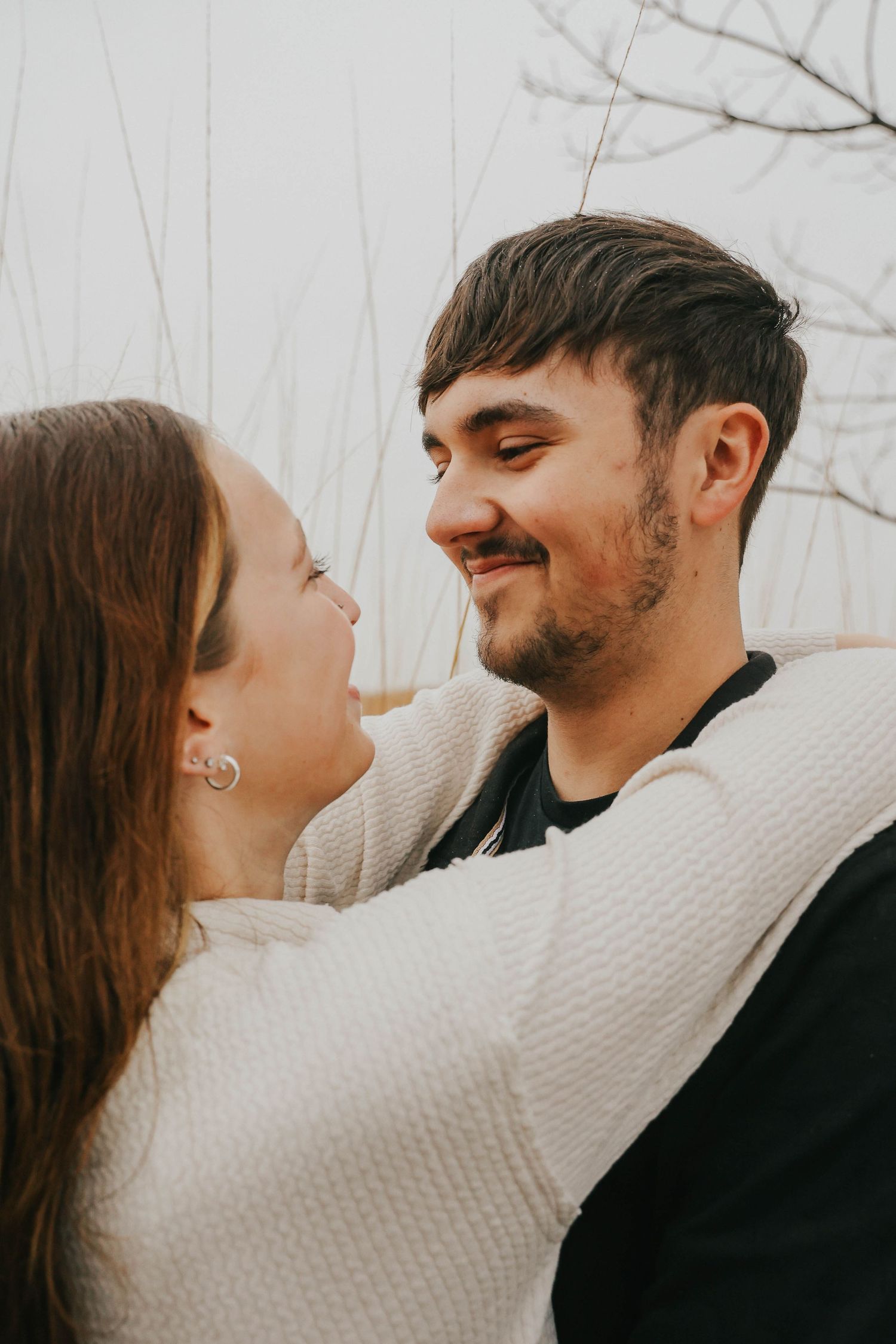 Intimate close-up of a couple in warm sweaters sharing a joyful moment together.
