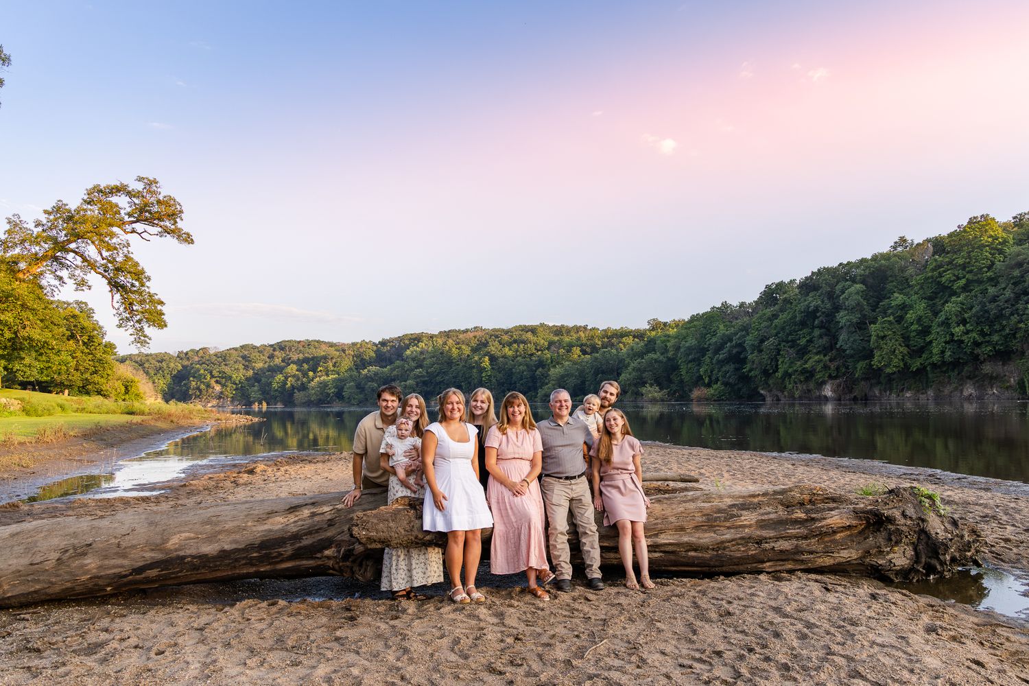 A scenic collage of lakeside photos showing a group in light-colored outfits posing on rocks and shoreline at sunset.