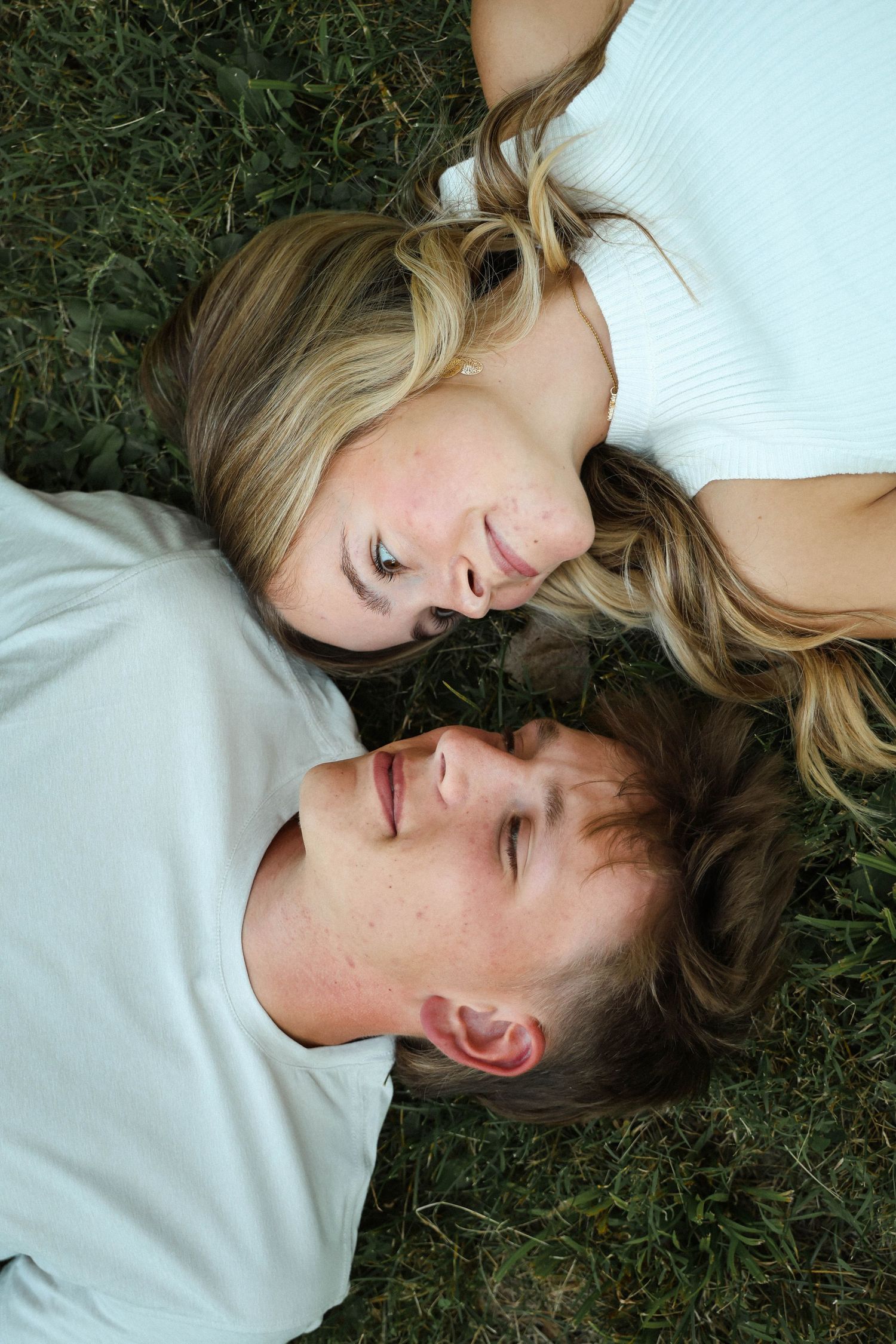 Intimate overhead portrait of couple laying on grass together.