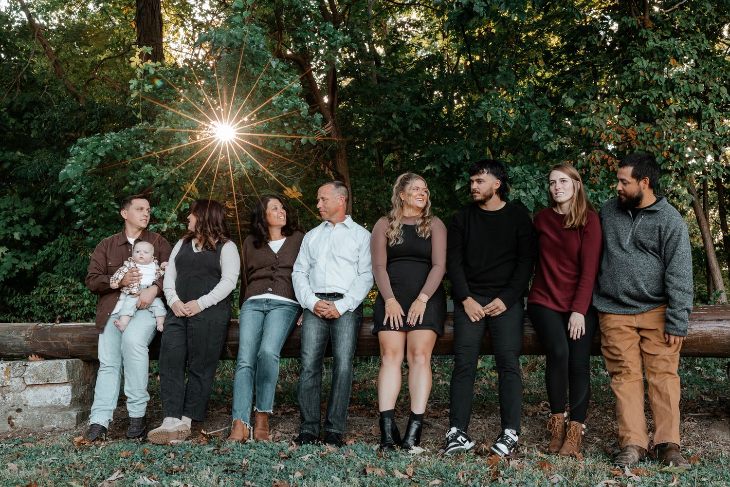 A group of people sitting together outdoors on stone steps during golden hour sunlight.