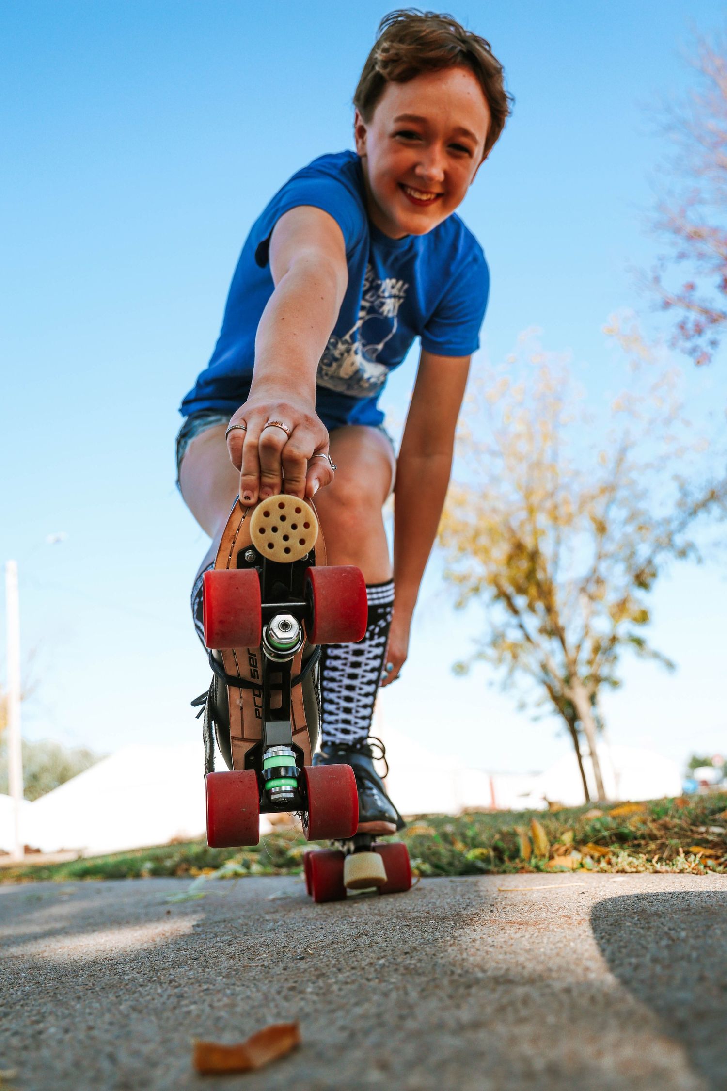 Low angle shot of someone grabbing their wheel while wearing a blue t-shirt.