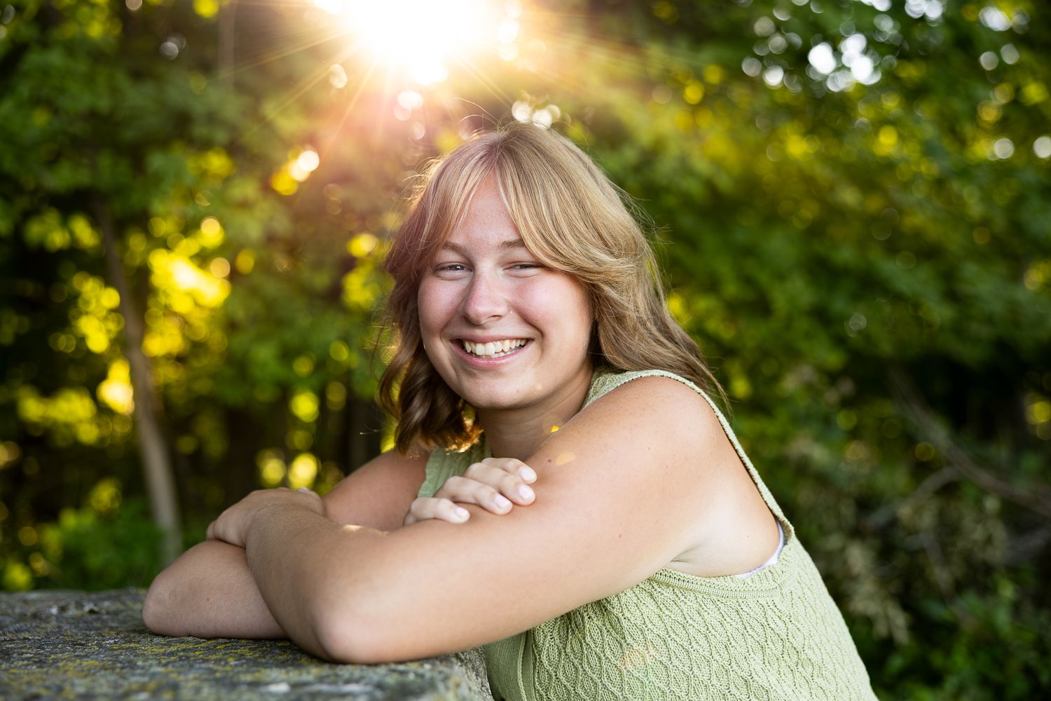 Outdoor portrait session at sunset with warm golden light filtering through trees in a natural setting.