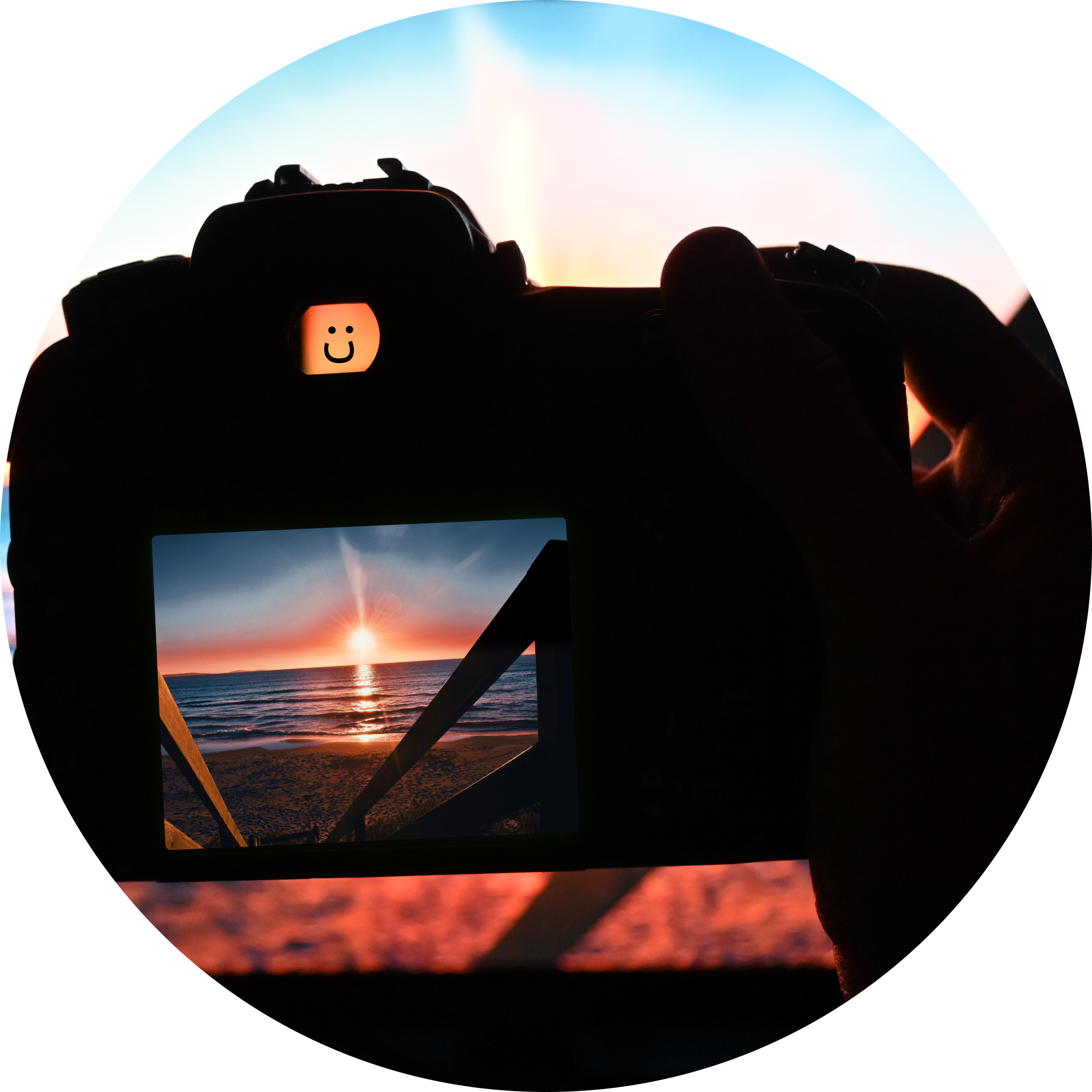 Silhouette of camera displaying sunset through viewfinder on beach.