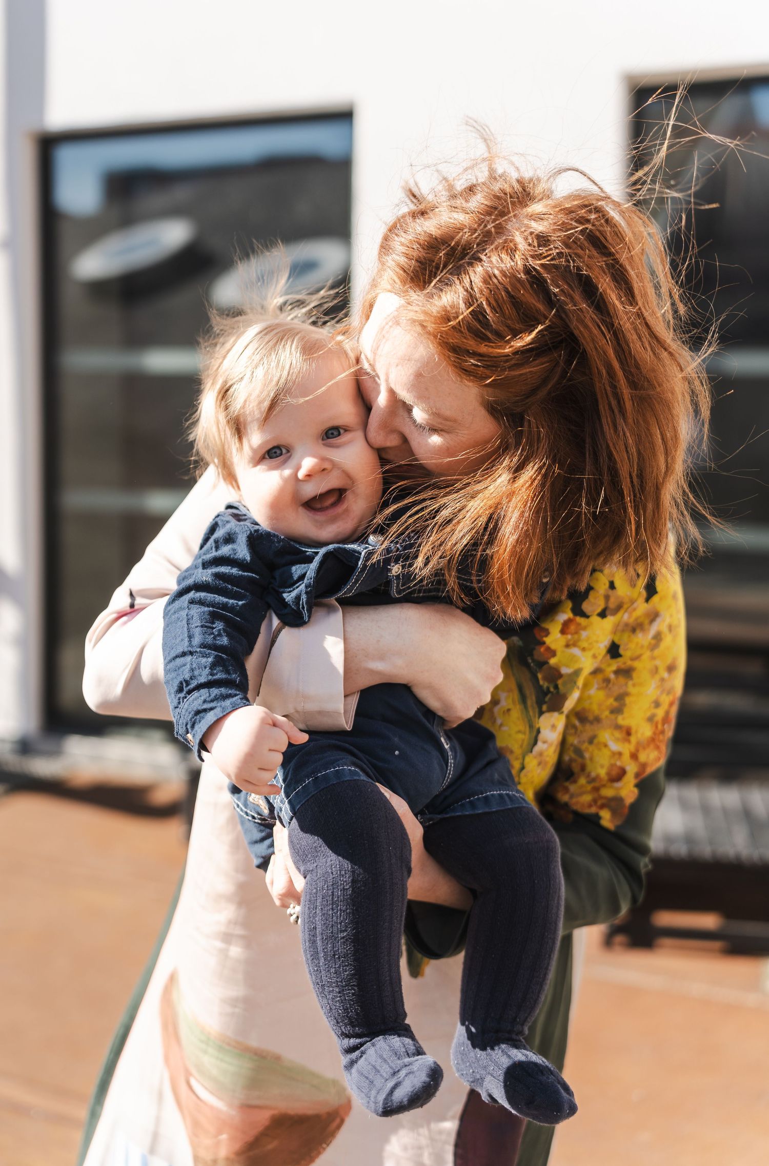 A heartwarming outdoor moment shows affectionate interaction between parent and child on a sunny day.