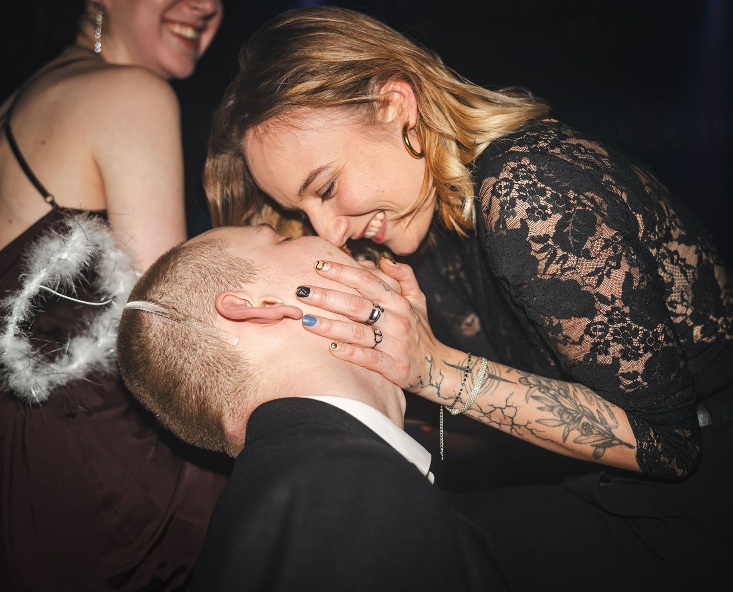 A candid moment captured at a wedding showing affection between a couple in formal attire.
