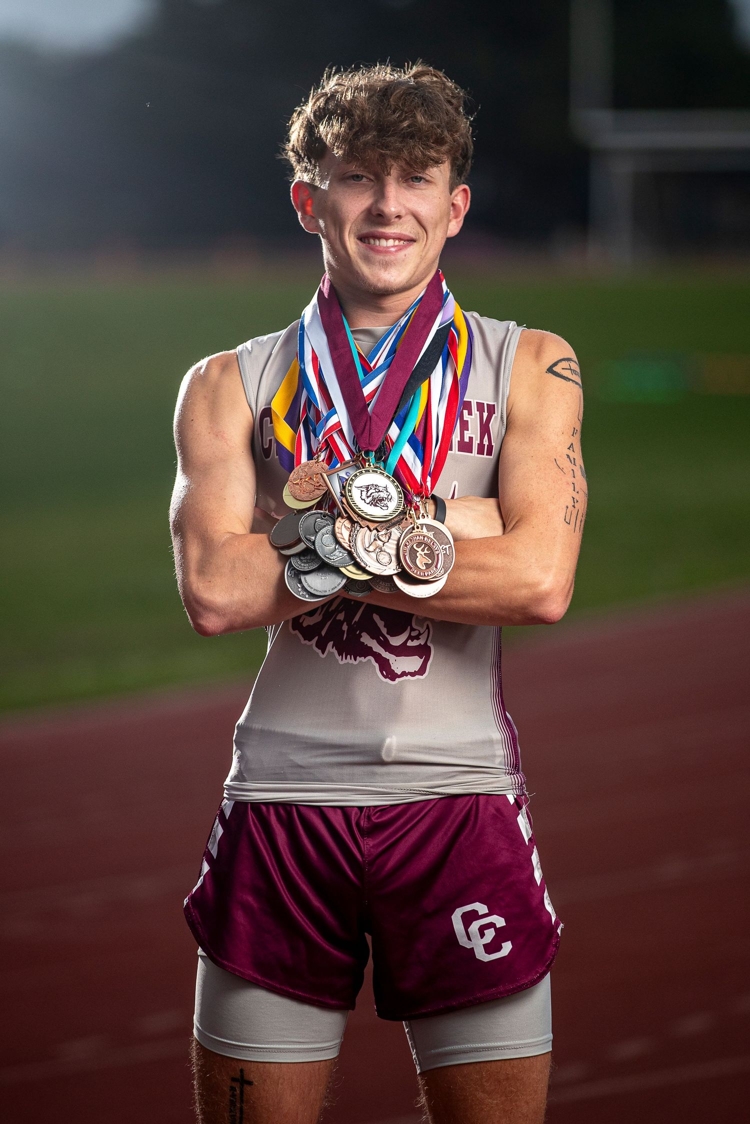 Athlete displaying multiple medals earned in track and field competition.