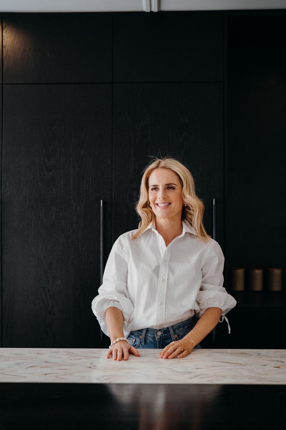 Professional lifestyle portraits of someone in a white button-down shirt against a dark background.