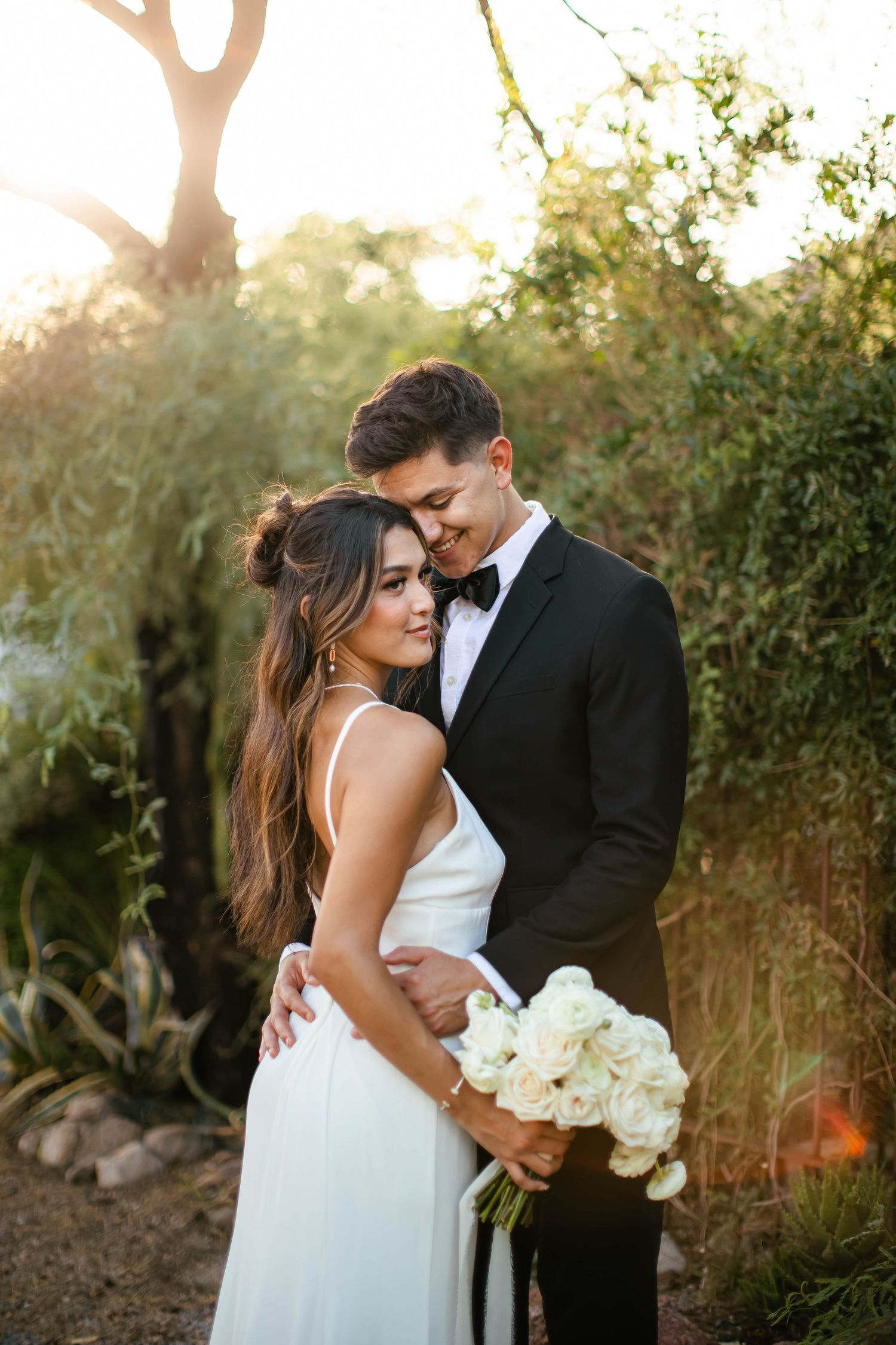 Intimate wedding portraits at golden hour with desert landscape in background.