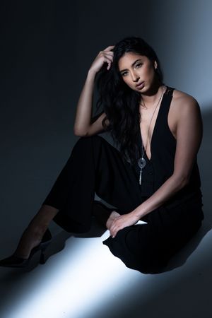 Dramatic fashion photo series showing model in black outfit posing against dark background with dramatic lighting.