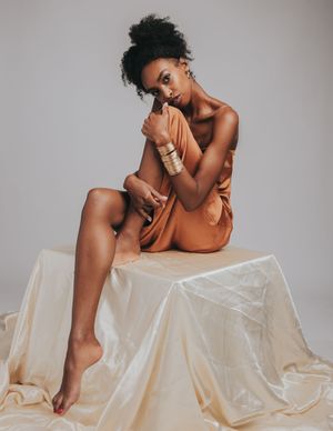 Artistic nude photography series showing graceful poses against white fabric and neutral background.