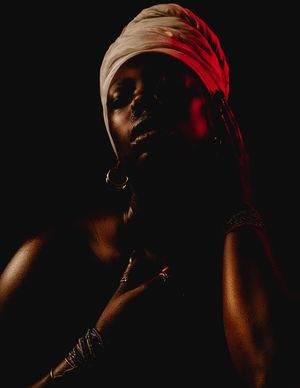 Low-key portrait series in dark lighting with dramatic red accent illumination creating moody shadows and silhouettes.