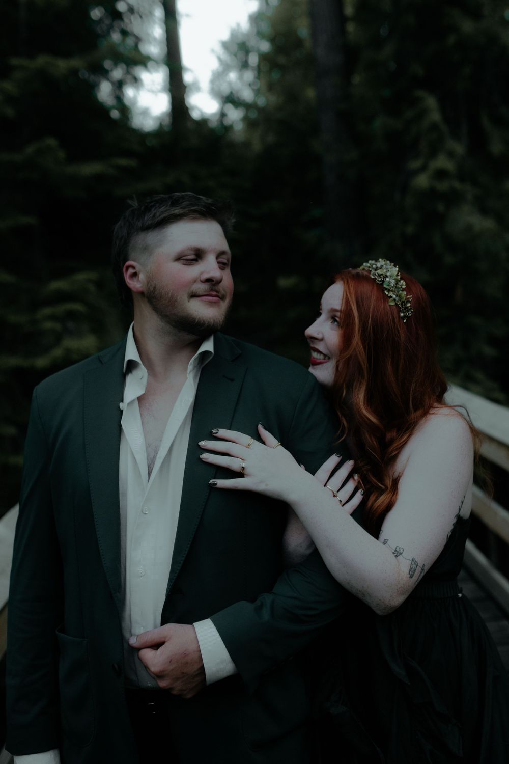An intimate couples portrait session in a shadowy forest setting.