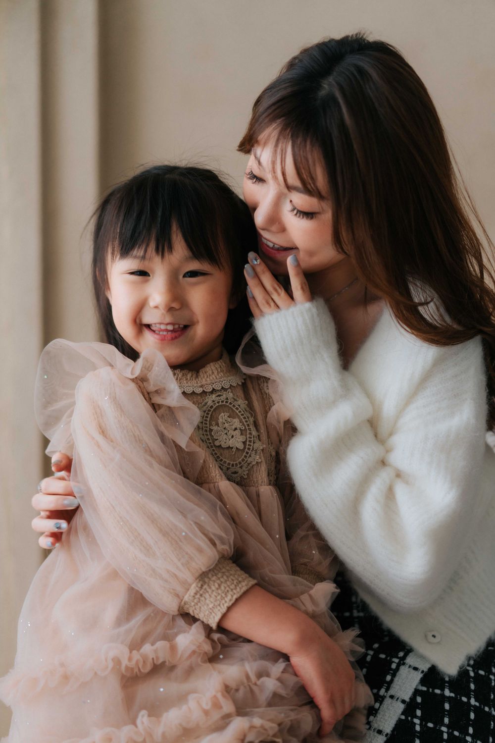 Two people share joyful moments and laughter while sitting together on a bed.