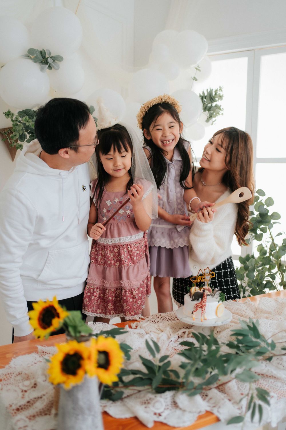 Family gathering around a festive table decorated with sunflowers and greenery.