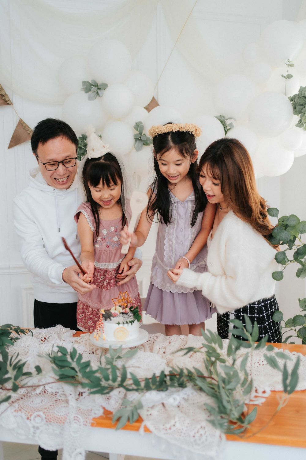 Group celebrating around a decorated table with cake and festive decorations.
