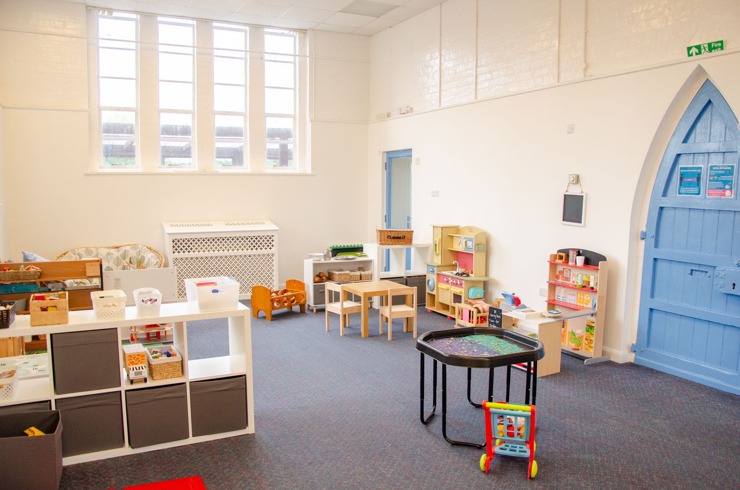 Spacious classroom with arched windows and organized learning stations.