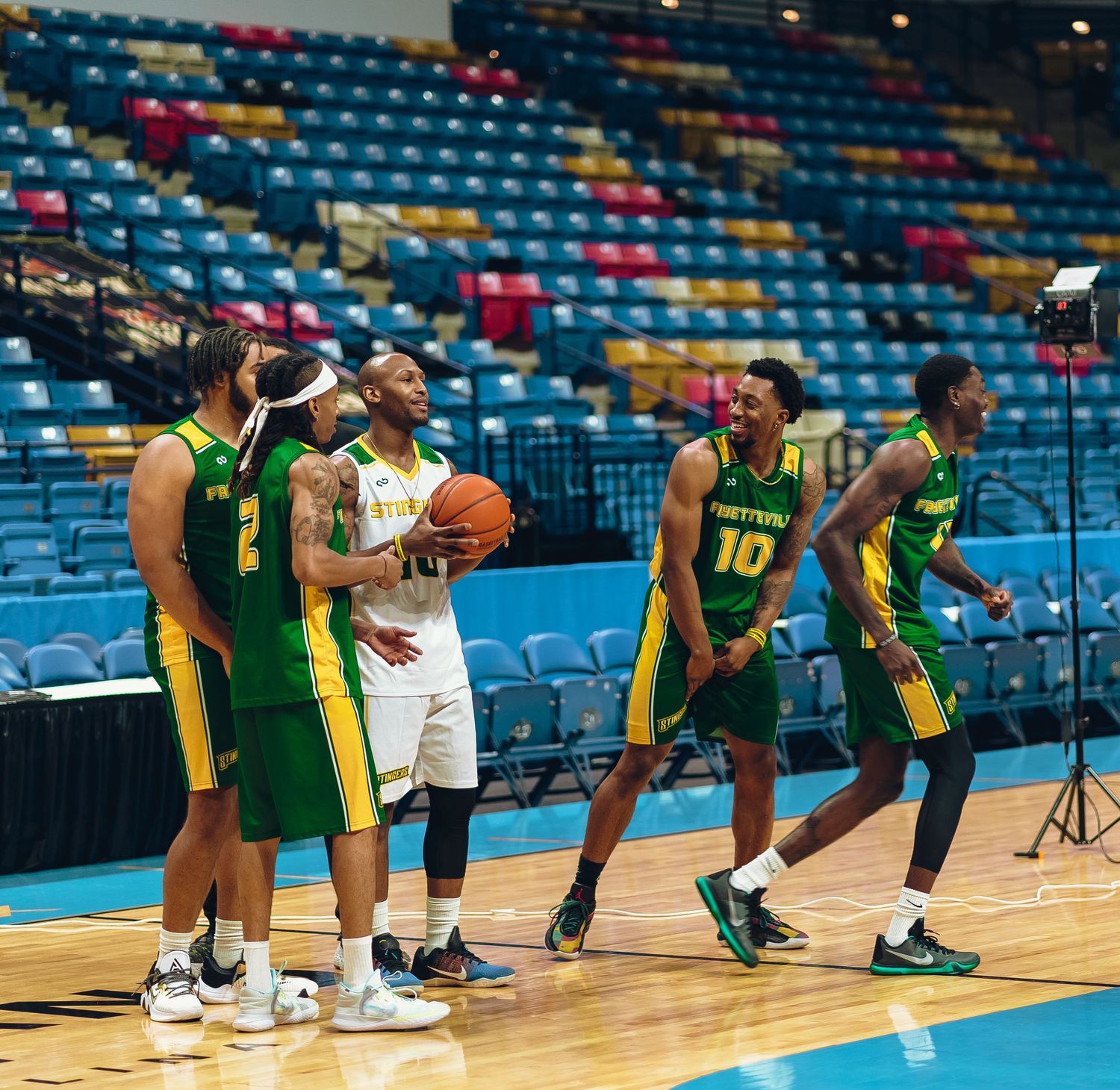 Basketball players in yellow and white uniforms competing during professional game.