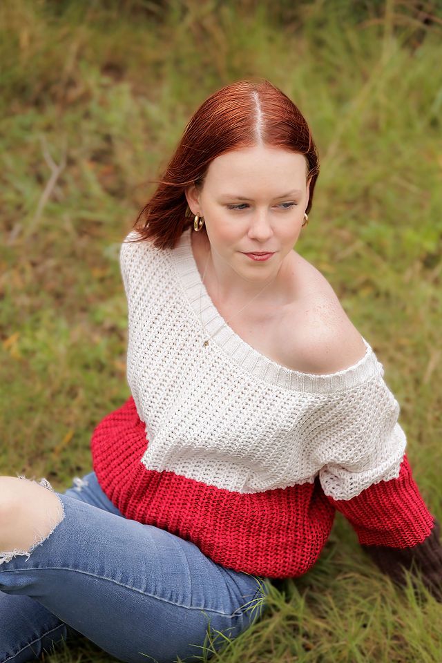 A cozy autumn portrait featuring a color block sweater and distressed jeans in a natural setting.
