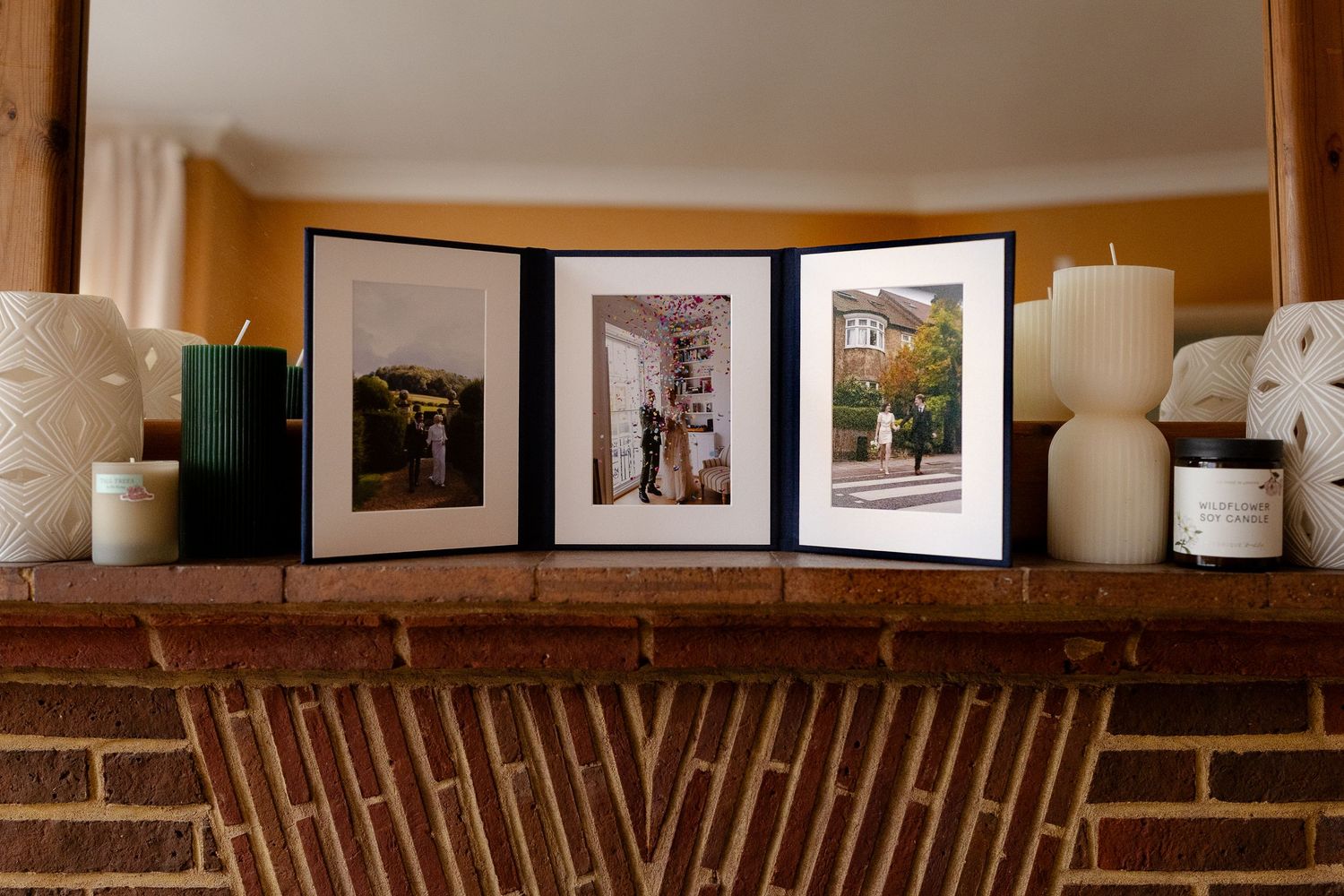Open white photo album displayed next to small potted cacti on dark surface.