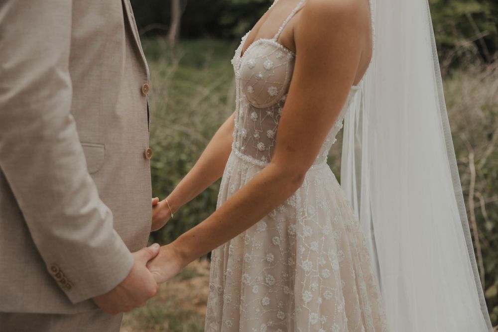 Close-up details of a flowing wedding dress with delicate lace patterns.