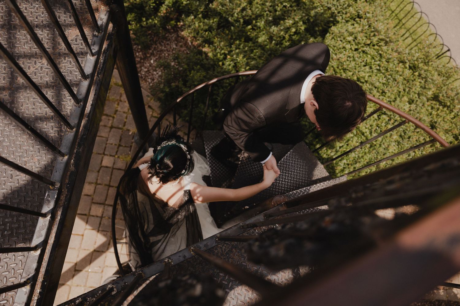 A high-angle view of a photographer at work on outdoor stairs in natural lighting.