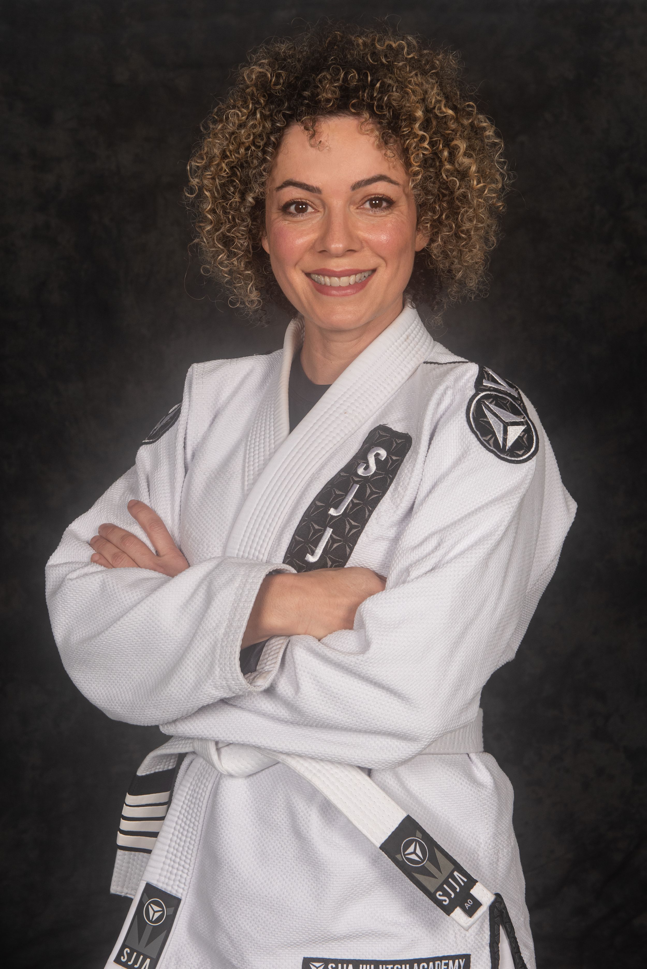 Martial artist in white gi showing different poses against dark studio backdrop.