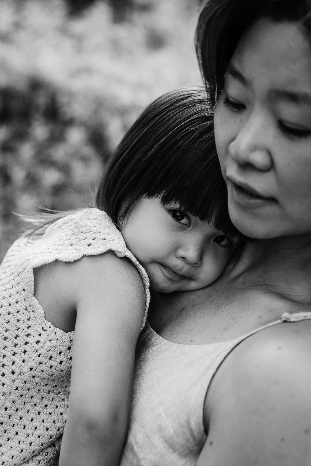 Black and white close-up photo showing an emotional embrace in tender light.