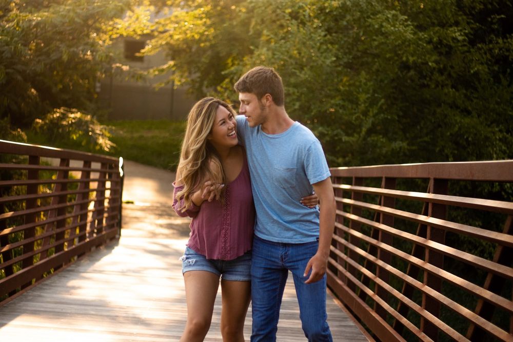 engaged couple walking on a bridge in downtown Acworth