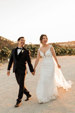 Asian bride and groom walk in front of the sunset after getting married in Paso Robles California at Cass Winery.