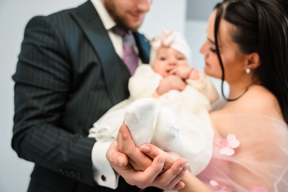 A series of photos showing tender moments between parents and their newborn baby during a baptism ceremony.